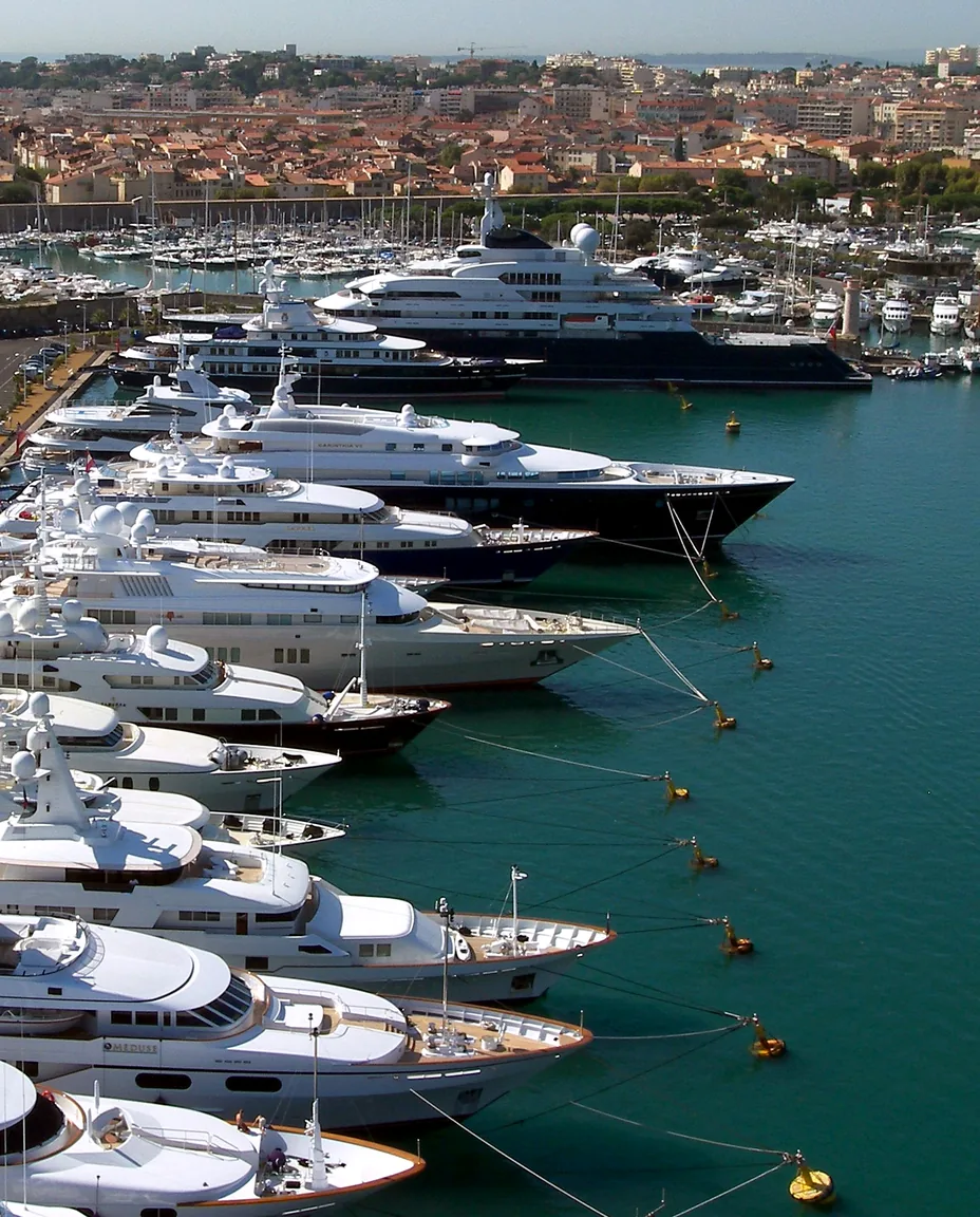 Les superyachts du quai des milliardaires au port Vauban, la vieille ville d'Antibes derrière